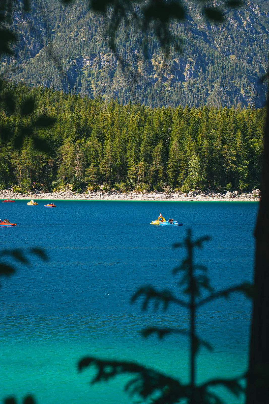 Pedal boats on the turquoise water of an alpine lake